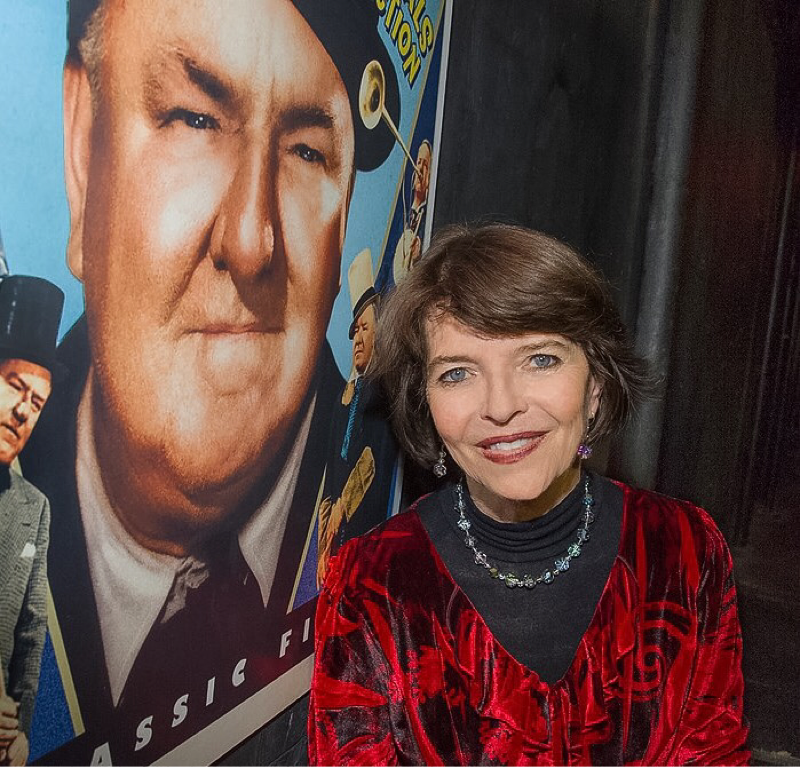 Dr. Harriet Fields standing next to W.C. Fields: Comedy Essentials Collection poster.